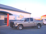 Dodge truck with grille guard, tonneau cover, steps, and accessories by the Pickup Guy.